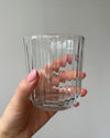 A hand holding a sparkling clean drinking glass