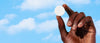 Hand holding a cleaning tablet against a blue sky background
