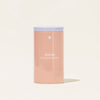 A peach-colored cylindrical container labeled Oxi Laundry Booster Forever Tin with a white lid, ideal for maintaining fresh clothing, set against a light beige background.
